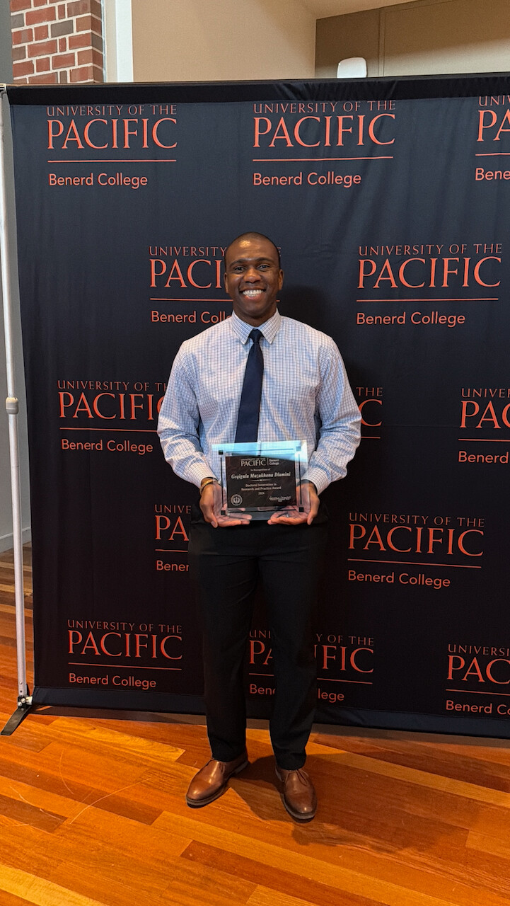 Dr. Geqigula Dlamini holding the University of the Pacific Doctoral Innovation in Research and Practice Award